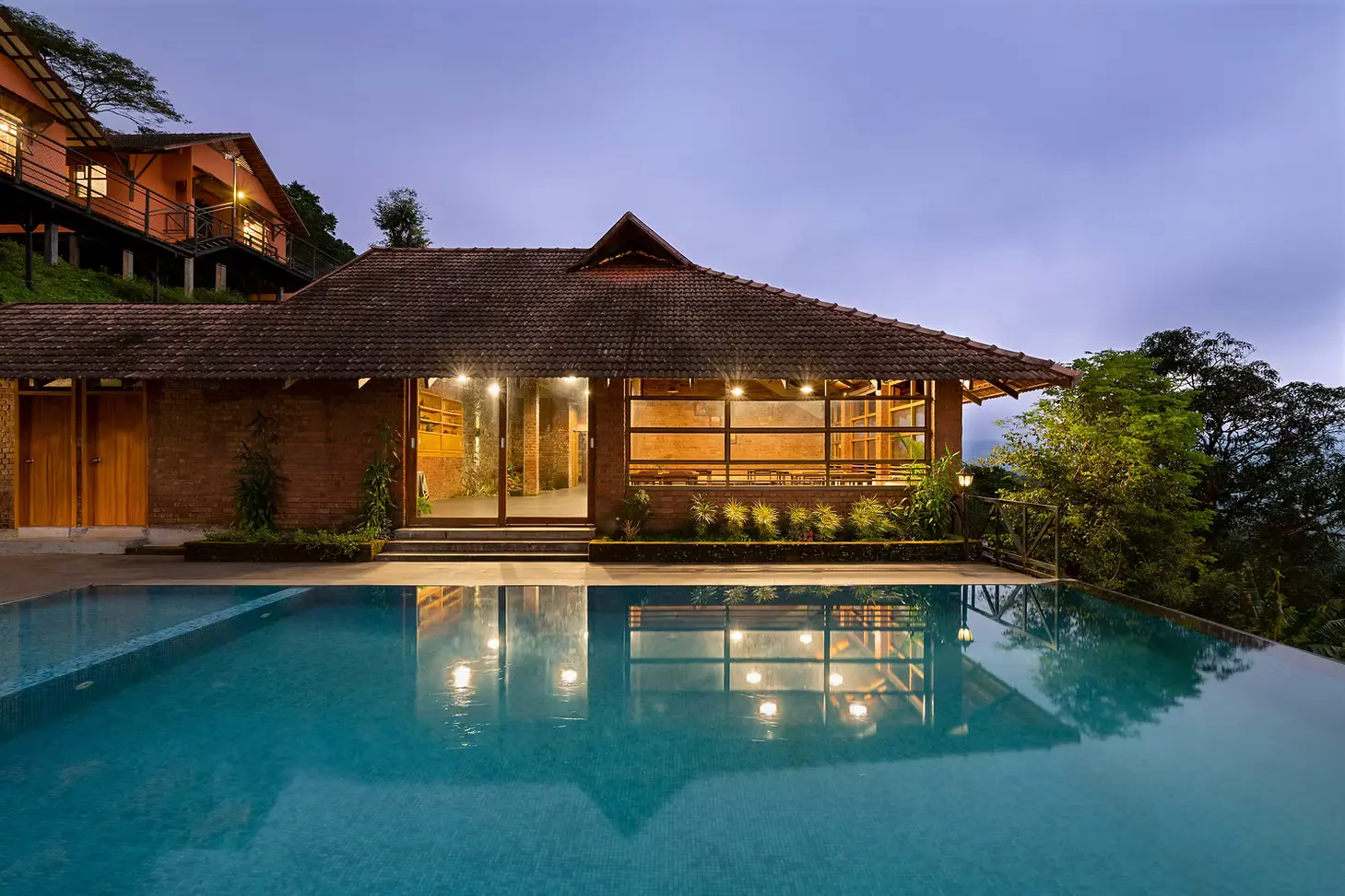 Infinity pool and hospitality block in evening light